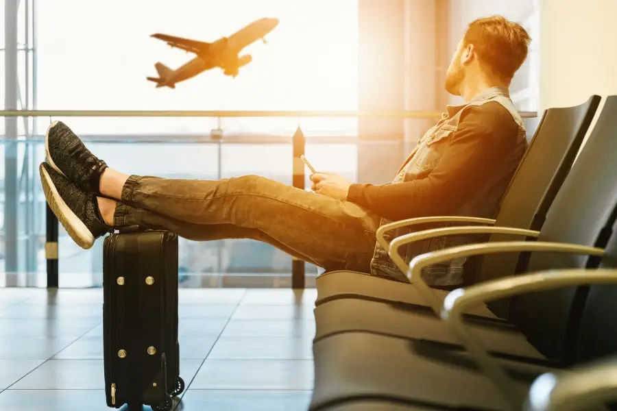 best time to travel to Jamaica and how to prepare - blog - man sitting in an airport waiting for his Plane